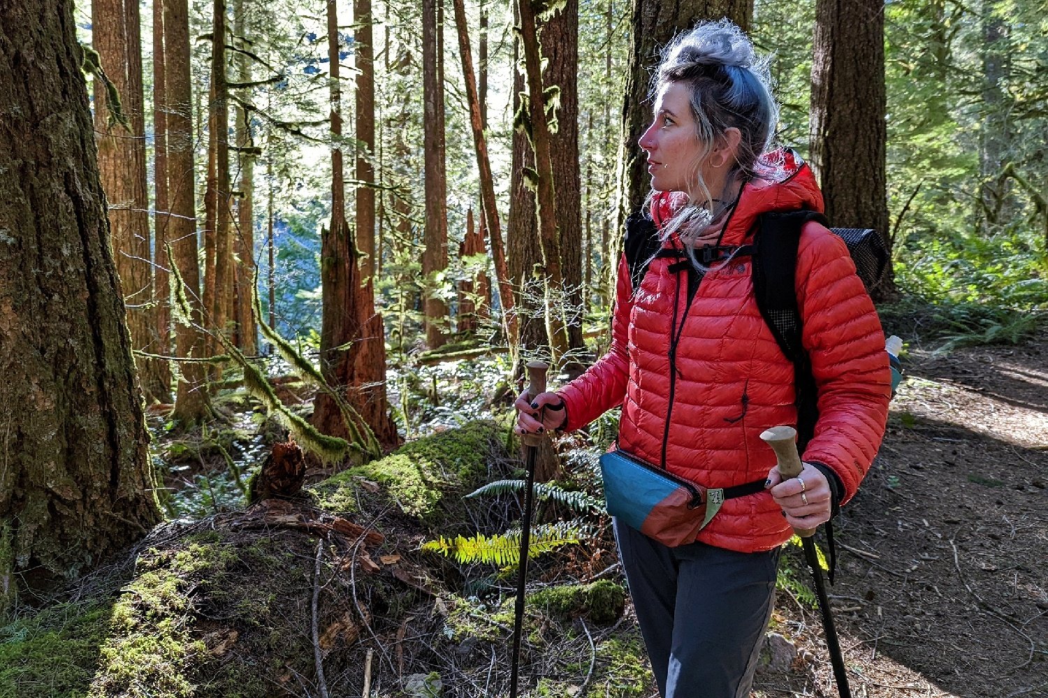 A hiker wearing the Hightail Designs Ultralight fanny pack on a trail in a forest