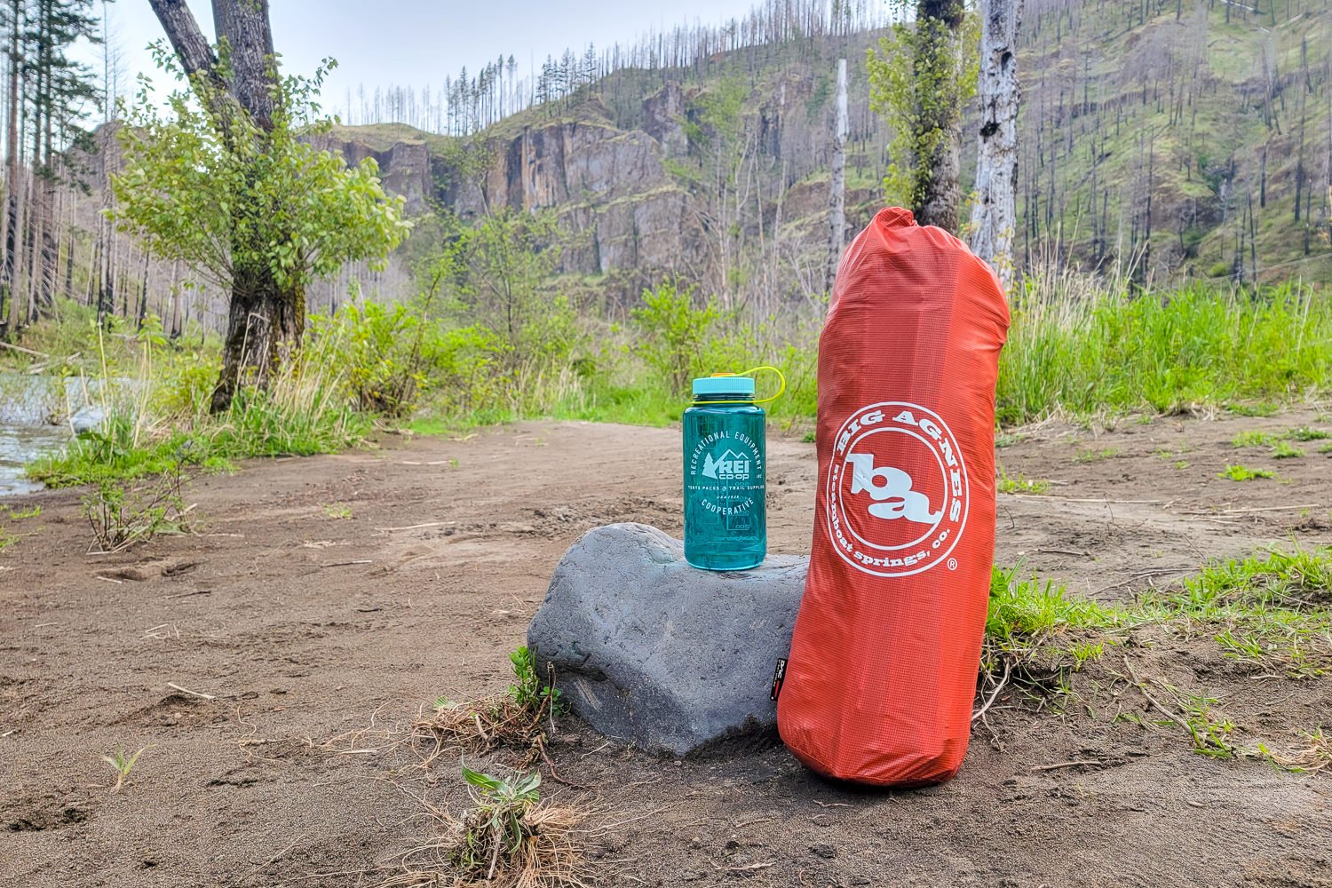 The Big Agnes Copper Spur HV UL2 Tent in its stuff sack next to a Nalgene water bottle for scale