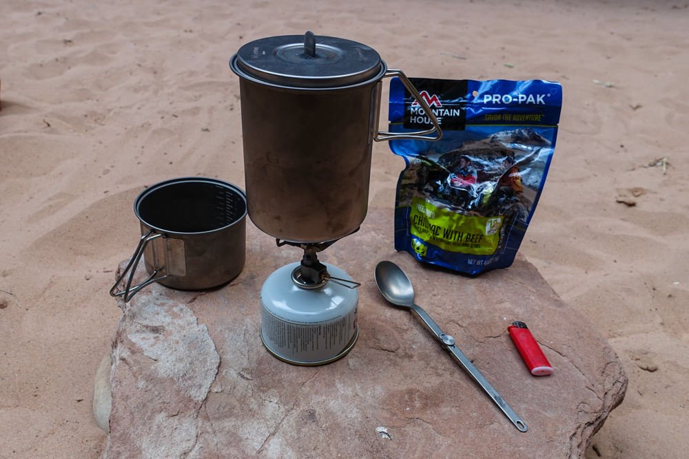 The Snow Peak Mini Solo Cook Set sitting on a rock next to a freeze dried meal from Mountain House