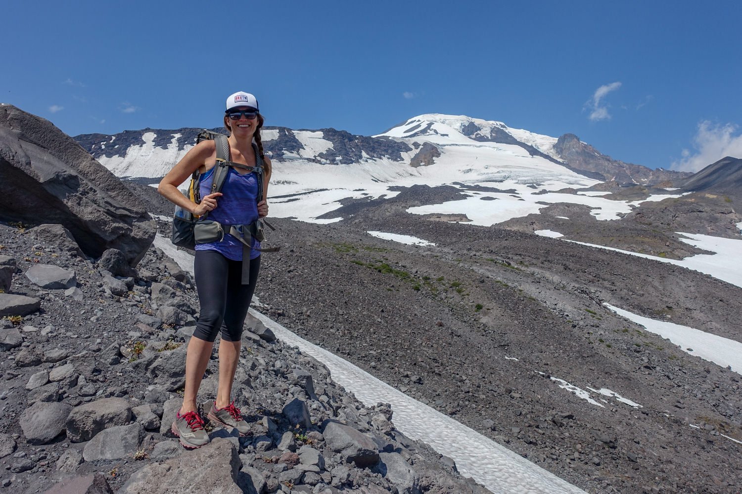 A hiker summiting a mountain in a pair of crop leggings