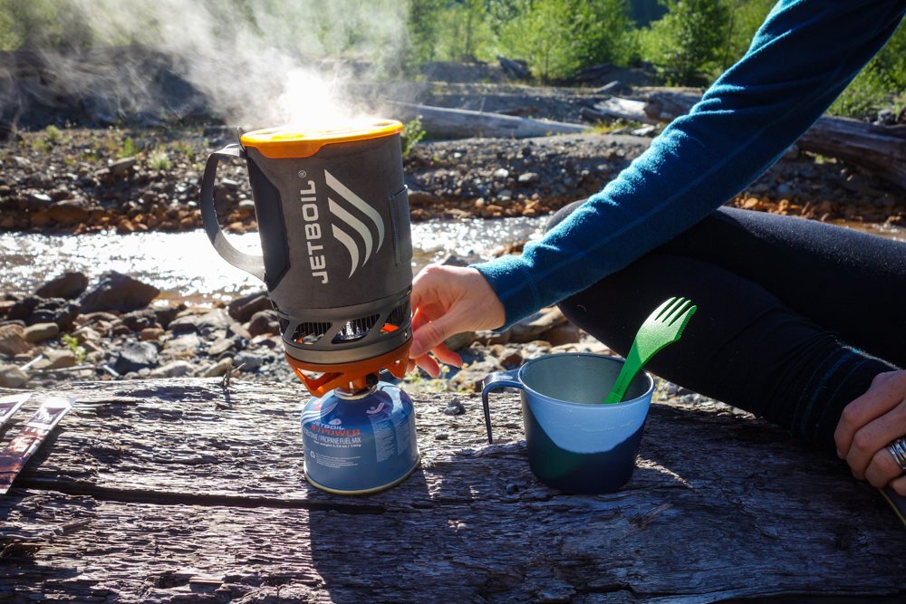 A hiker adjusting the Jetboil Flash with steam rising