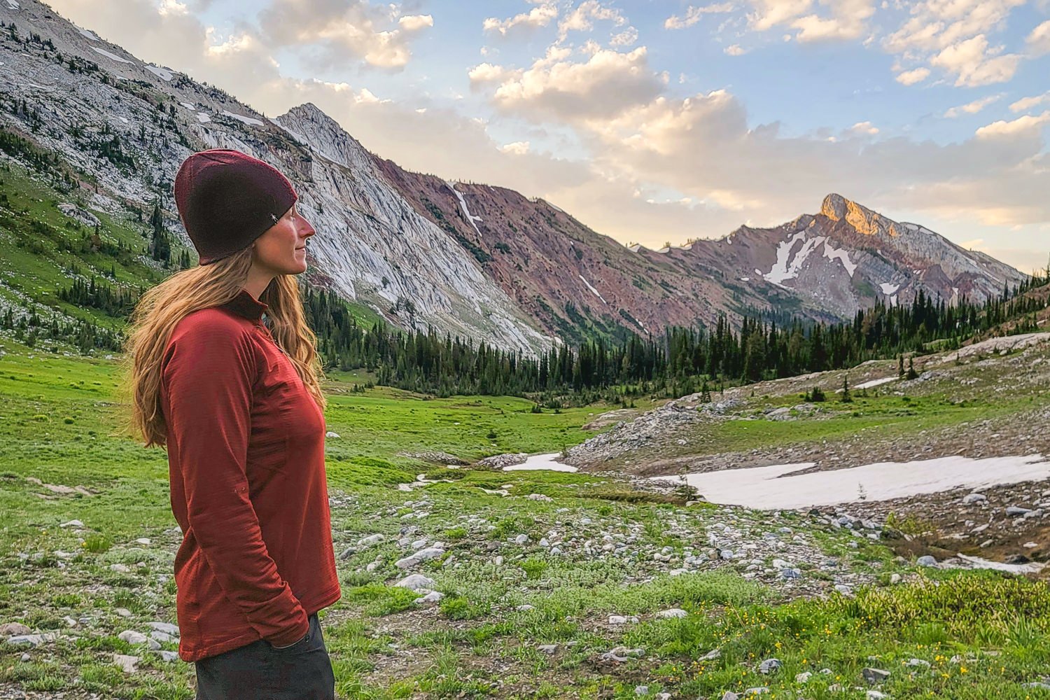 A backpacker wearing the Outdoor Research Vigor Fleece in a mountain basin