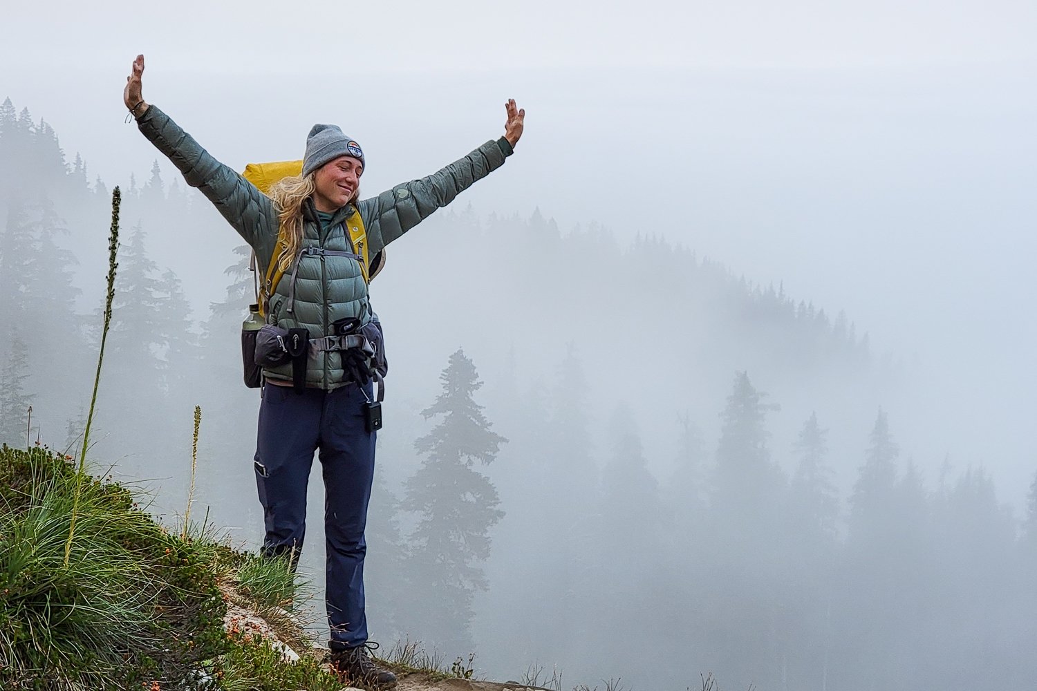 A backpacker wearing the REI 650 Down Jacket in the foggy Goat Rocks Wilderness