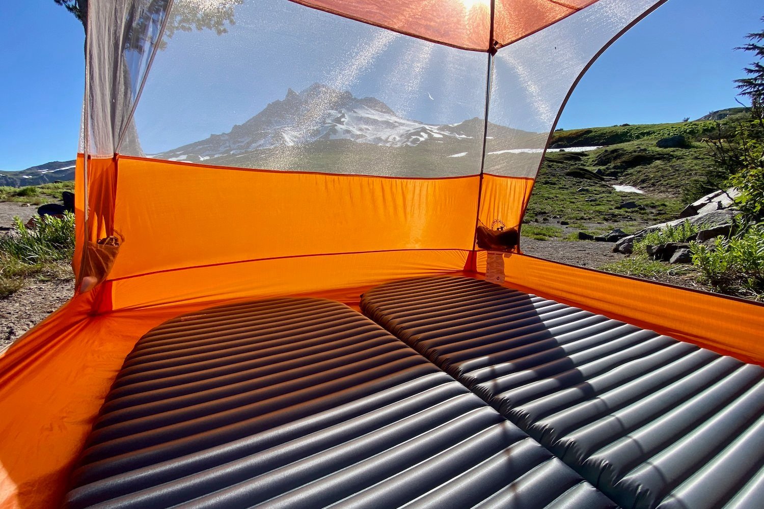 A pair of Therm-a-Rest NeoAir Uberlite sleeping pads in a backpacking tent with Mt. Hood in the background