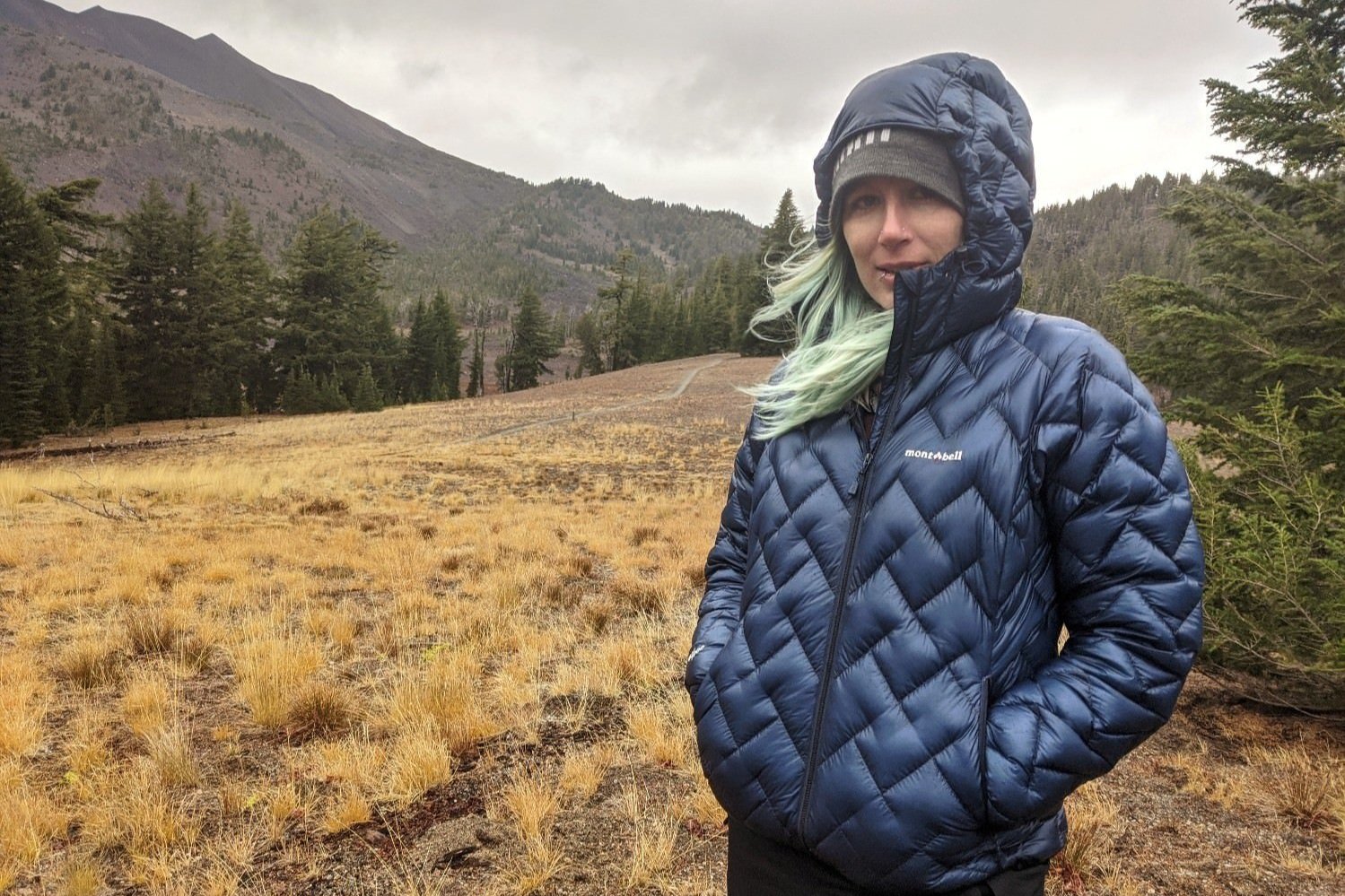 A backpacker wearing the Montbell Plasma 1000 Alpine Parka on a fall trip