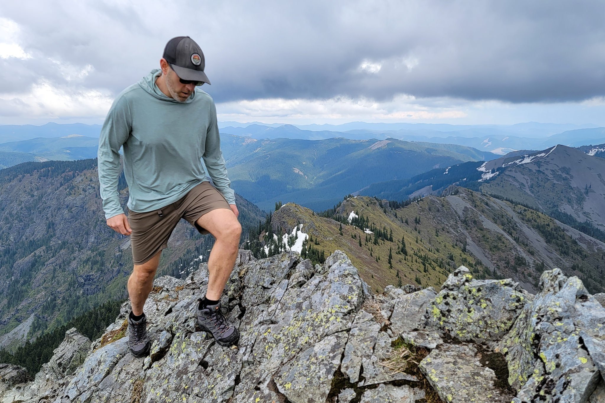 A hiker on top of a mountain wearing Prana Stretch Zion Shorts