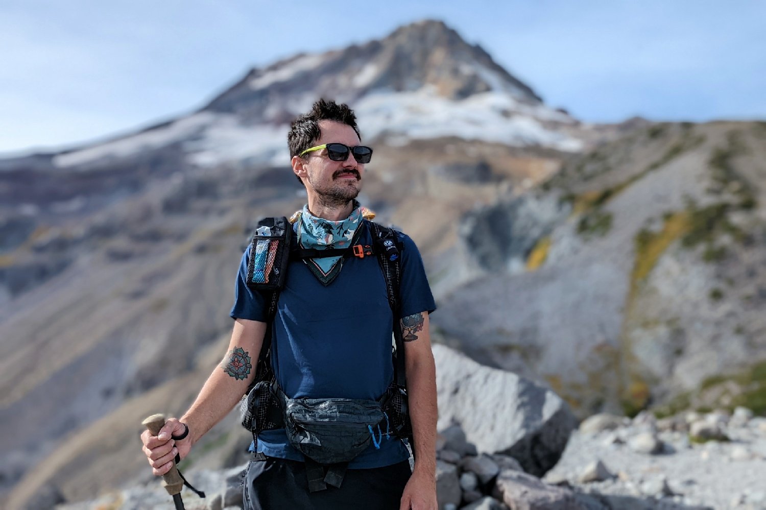 A hiker wearing the Hyperlite Mountain Gear Versa Fanny Pack in front of a mountain view