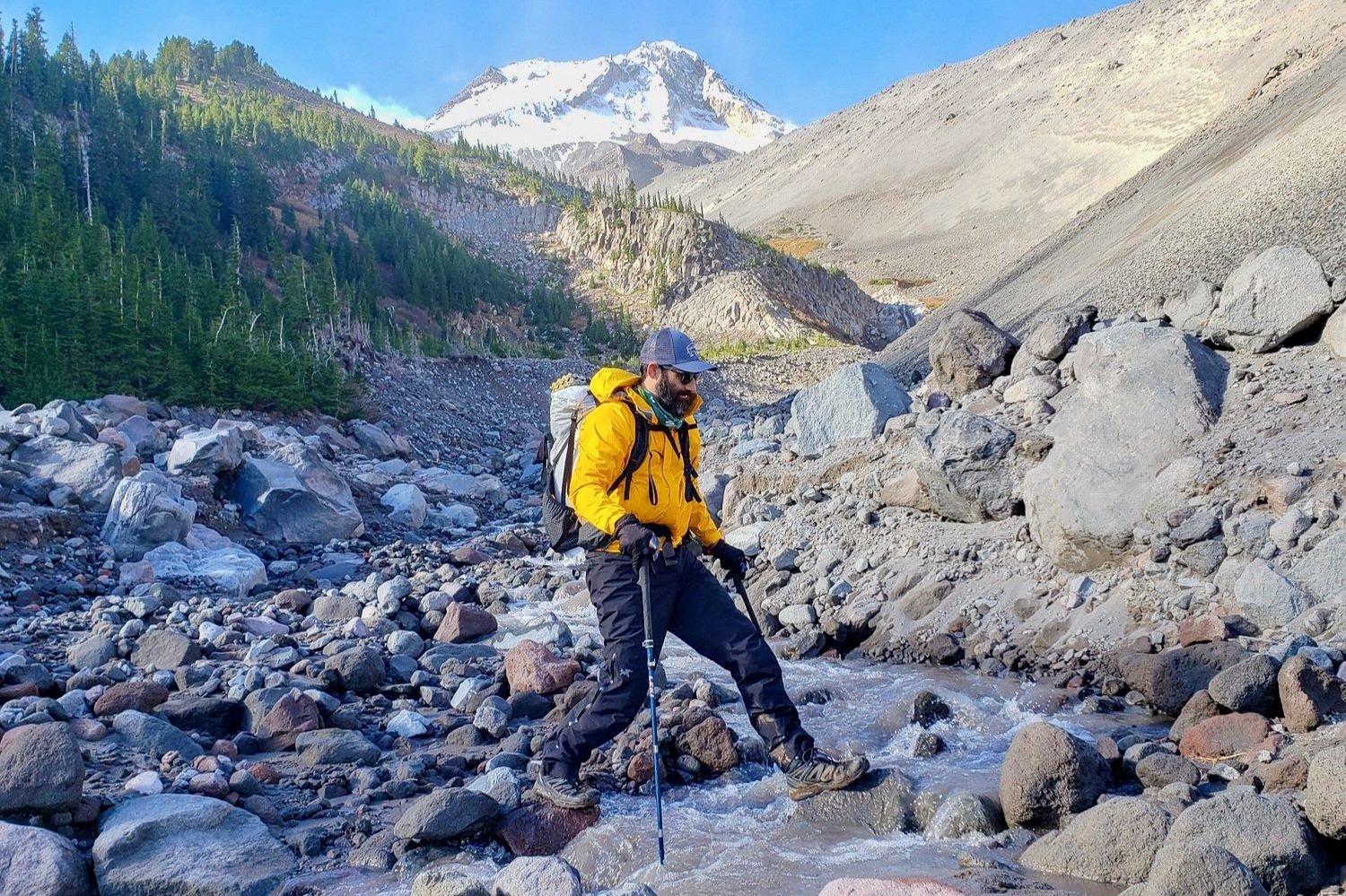 hiker crossing river wearing hiking boots