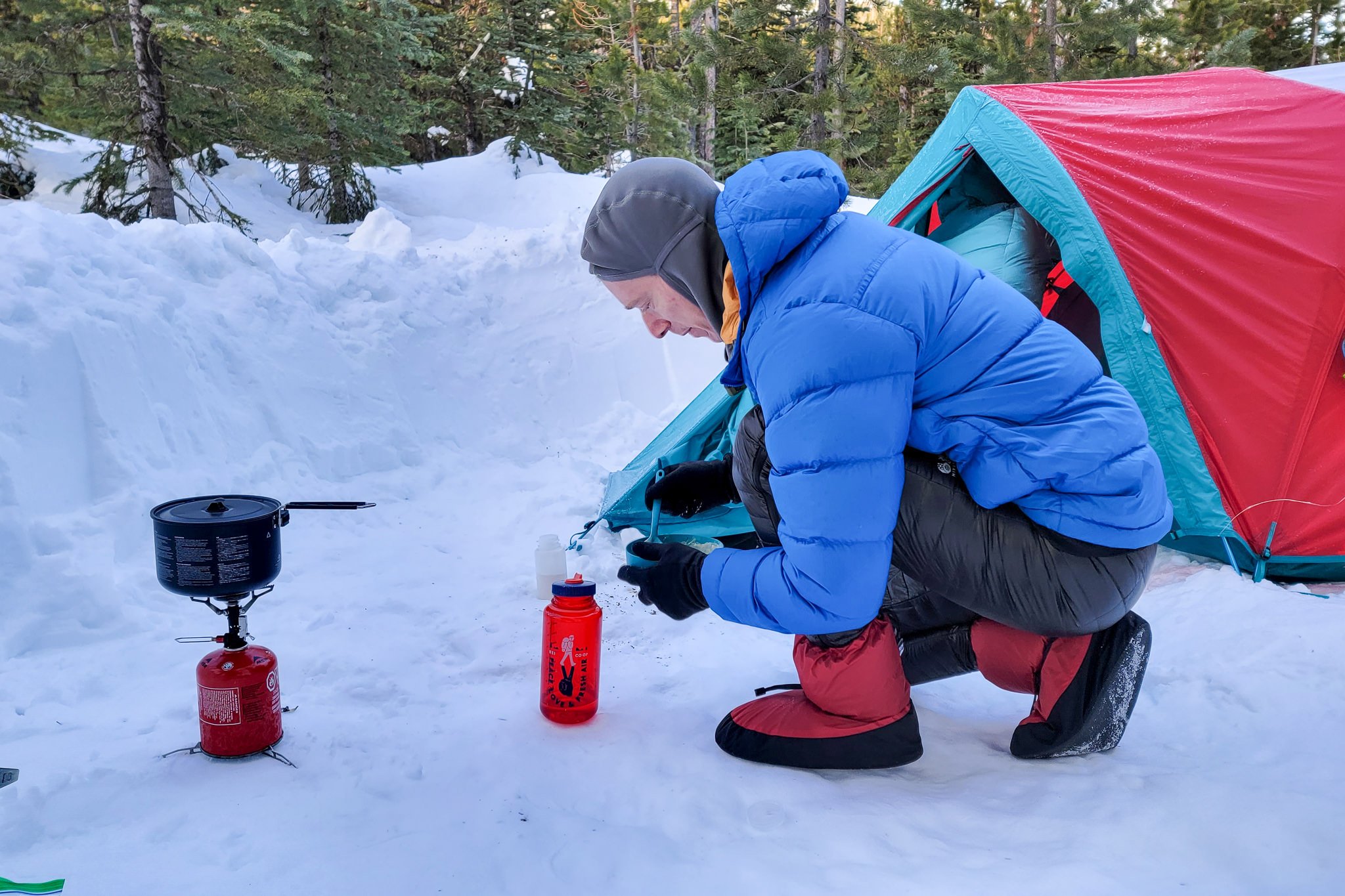 Wearing the Feathered Friends Down Booties in a snowy winter camp