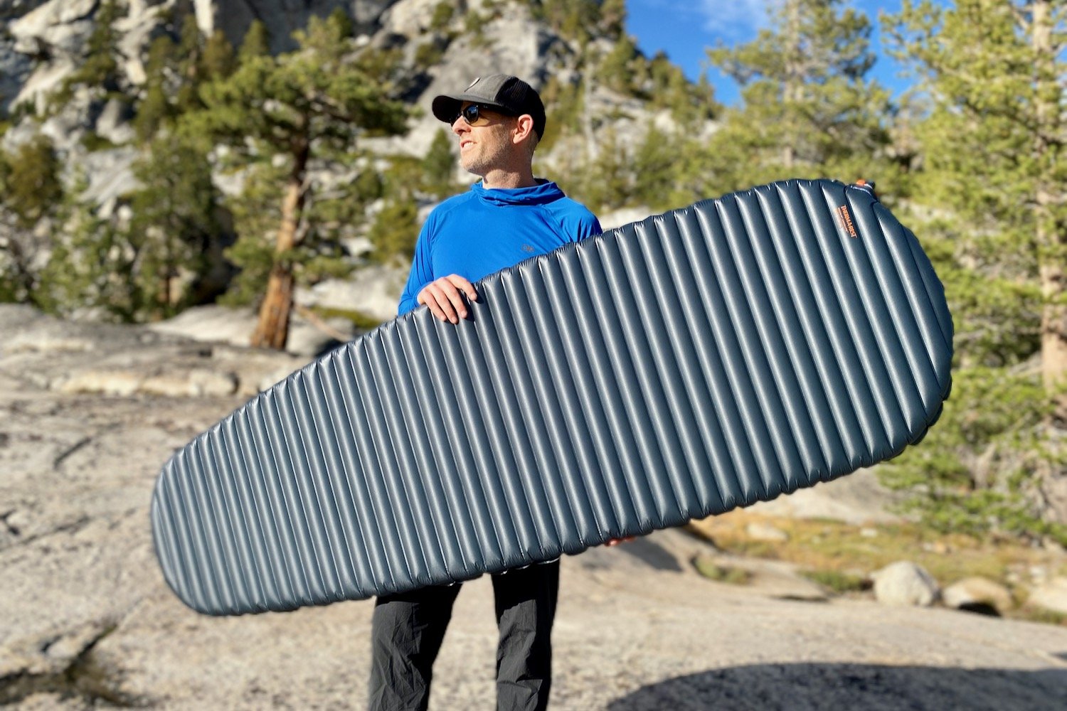 A backpacker holding the Therm-a-Rest NeoAir UberLite Sleeping Pad