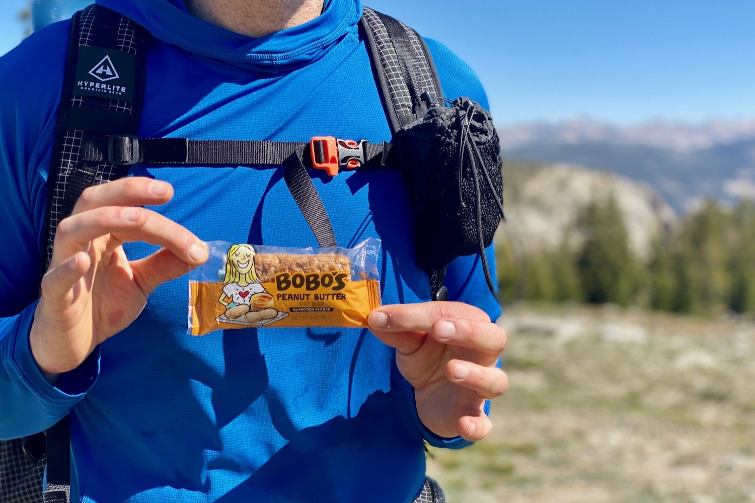 Closeup of a backpacker holding a Bobo's Oat Bar